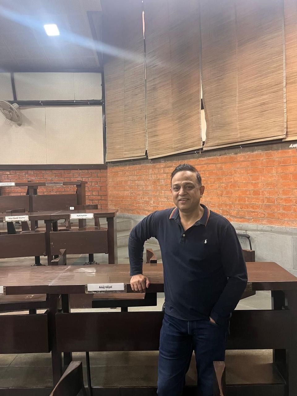 Rajat Goel next to his old desk from his student days at IIM Ahmedabad